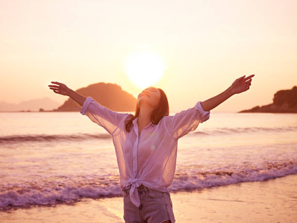 asian woman on beach enjoying sunrise
