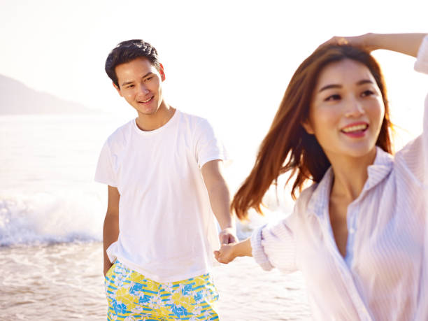 istock young asian couple relaxing on beach 817359716