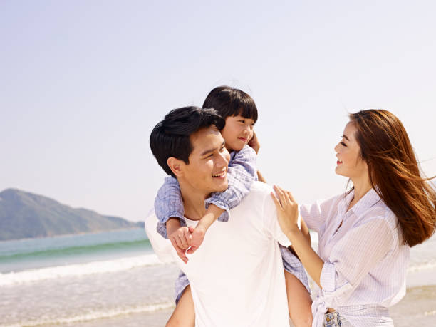 istock happy asian family having fun on beach 817362172