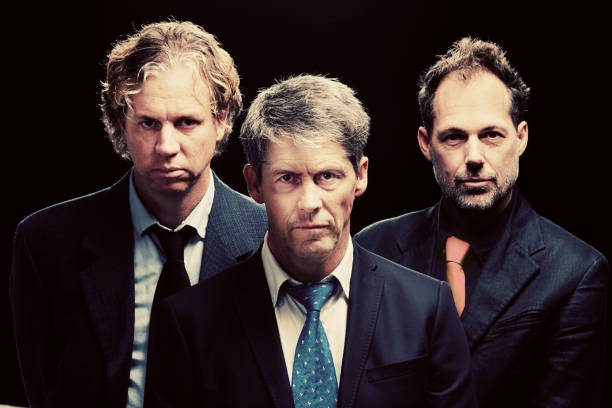 istock Three men in suits stare, looking ominous, at camera 817367638