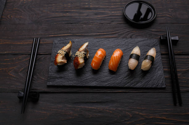 istock Sushi and rolls set in japanese restaurant on black wood 817388480