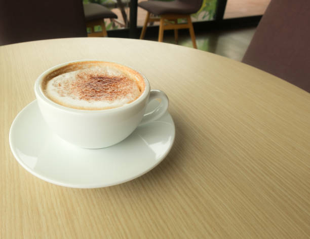 istock Hot latte in white cup put on wood table in coffee cafe. 817388728