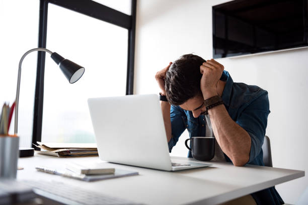 sad man working in office - using laptop contemplation accessibility contemporary imagens e fotografias de stock