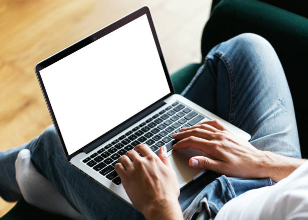 istock Man's hands using laptop with blank screen on desk in home interior. Work concept 817400928