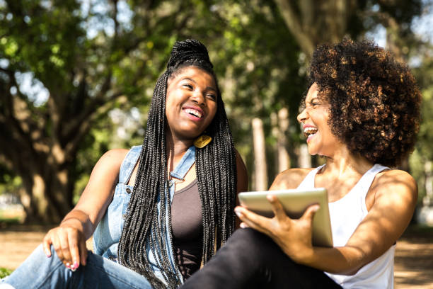 istock Afro friends using digital tablet in the park 817409560