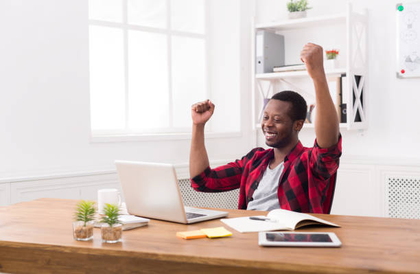 istock Happy businessman win. Winner, black man in office 817414624