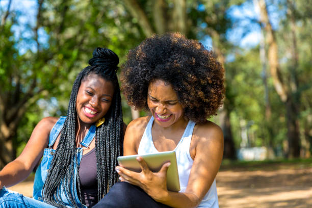 istock Afro friends using digital tablet in the park 817414692