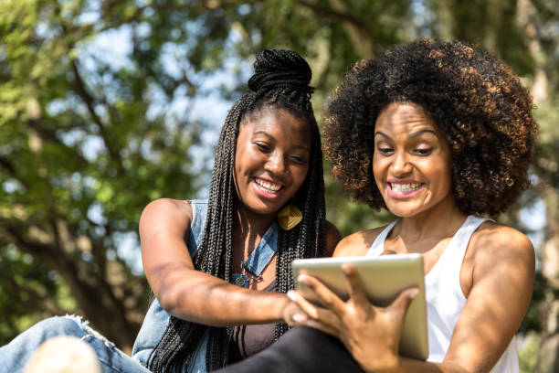 istock Afro friends using digital tablet in the park 817414718