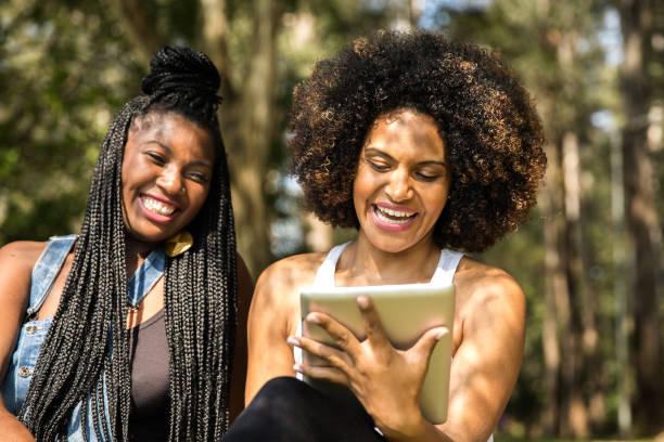 istock Afro friends using digital tablet in the park 817414838