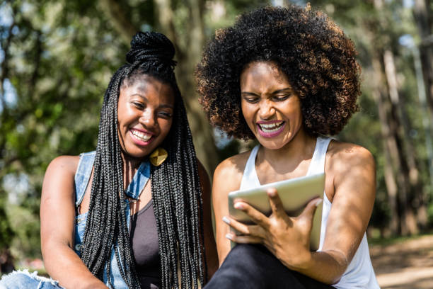 istock Afro friends using digital tablet in the park 817414846