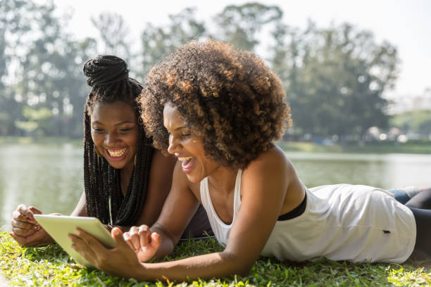 istock Afro friends using digital tablet in the park 817417516