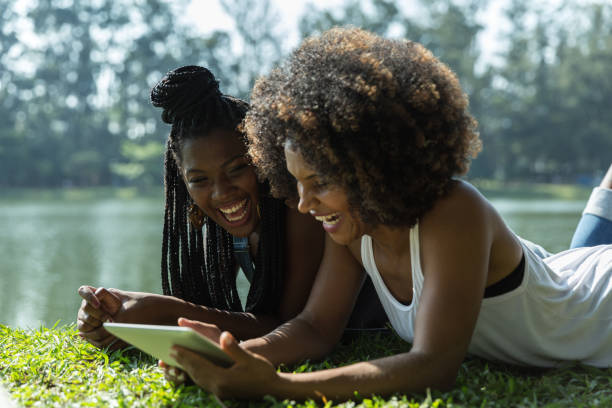 istock Afro friends using digital tablet in the park 817417522