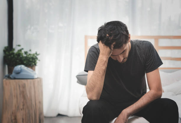 Stressed and Sad Handsome man. Stressed and Sad Handsome man sitting on the bed. Disappointment, edgy man stock pictures, royalty-free photos & images