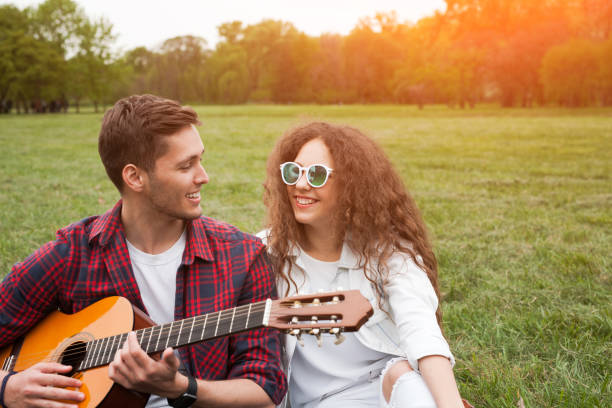 istock Couple spending time in park with guitar 817426802