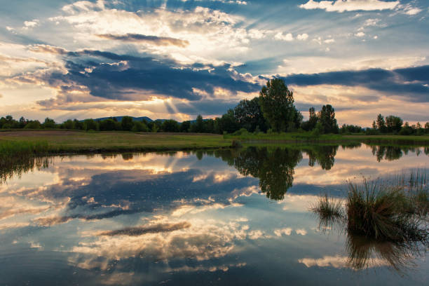 istock Breath-taking sunset over a lake with a nice cloudscape, sunbeam and reflection 817431174