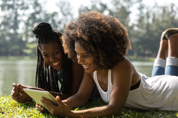 istock Afro friends using digital tablet in the park 817431548