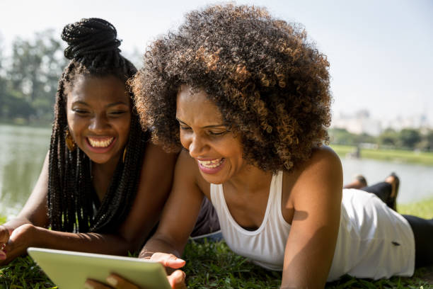istock Afro friends using digital tablet in the park 817431826