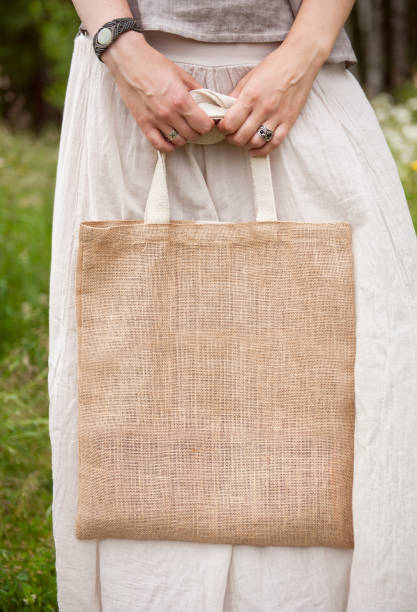 istock Woman holding empty linen bag. Template mock up 817436910