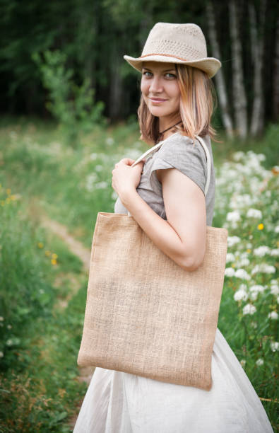istock Woman holding empty linen bag. Template mock up 817437844