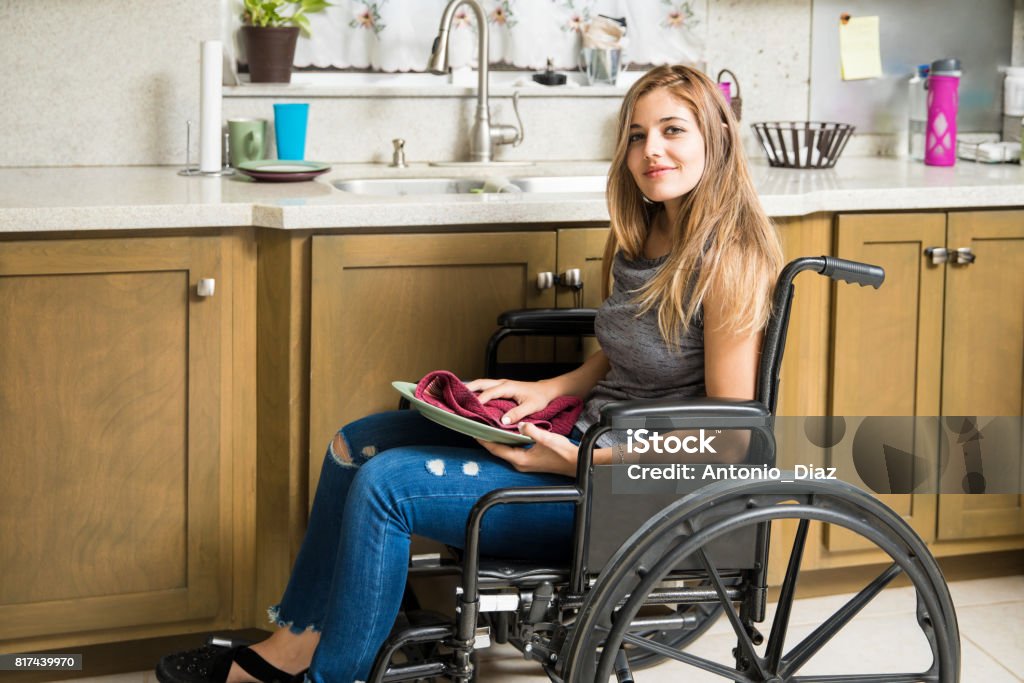 Mujer con discapacidad haciendo las tareas de la casa - Foto de stock de Diversidad funcional libre de derechos