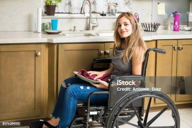 Mujer Con Discapacidad Haciendo Las Tareas De La Casa Foto de stock y más banco de imágenes de Diversidad funcional