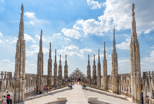 Milan, Italy - May 16, 2017: Tourists visit the roof of the Milan Cathedral (Duomo di Milano). Milan Duomo is the largest church in Italy and the fifth largest in the world.