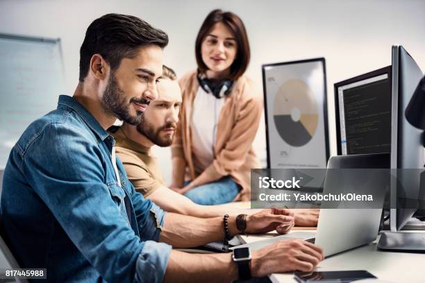 Cheerful Man Demonstrating Information To Partners Stock Photo - Download Image Now - Teamwork, Internet, Design