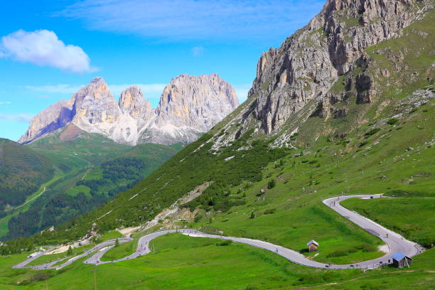 istock Idyllic Sas Pordoi, Winding Road, mountain pass and Langkofel pinnacle massif mountain range, wildflowers springtime, dramatic panorama and majestic Dolomites, Italy tirol alps 817455366