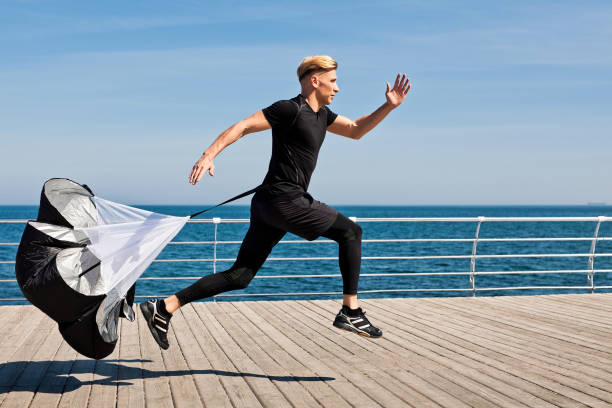 istock Side view of man running with parachute 817461714