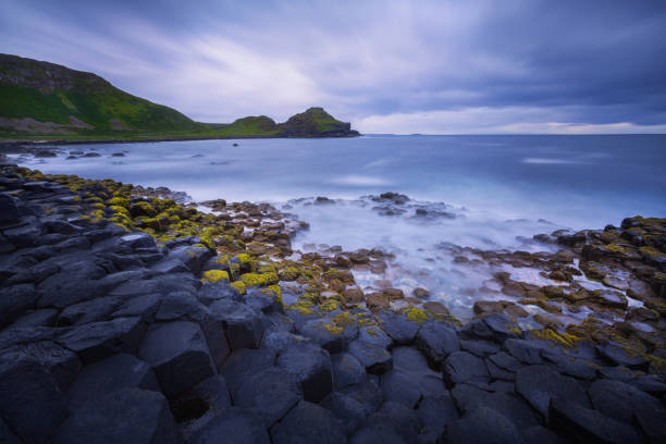 puesta de sol sobre las rocas formación calzada del gigante, condado de antrim, irlanda del norte, reino unido - national trust northern ireland uk rock fotografías e imágenes de stock