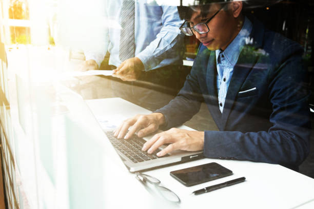 istock Team work process. young business managers crew working with new startup financial project. labtop on wood table, typing keyboard, texting message, analyze graph plans. 817466958