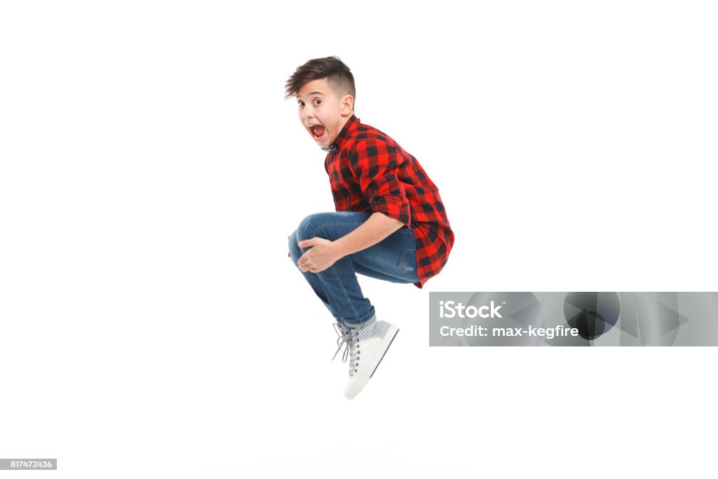 Cheerful jumping boy Side view of excited young boy jumping isolated on white. Child Stock Photo