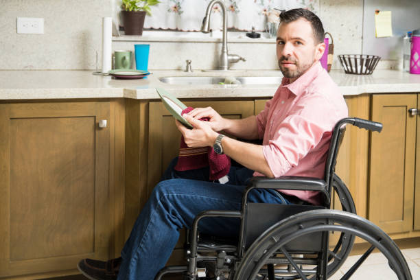 istock Sad man on wheelchair washing dishes 817472662