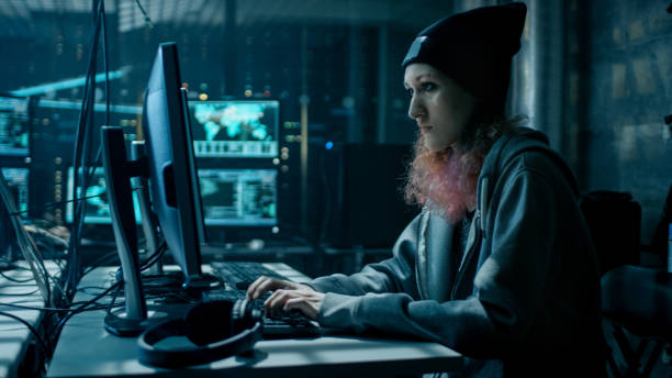 istock Nonconformist Teenage Hacker Girl Using Computer for Attacking Corporate Servers with malware. Room is Dark, Neon and Has Many Displays. 817486014