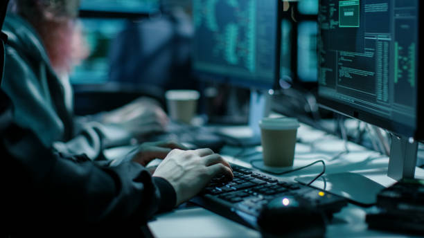 istock Close-up Shot of Hacker using Keyboard. There is Coffee Cups and Computer Monitors with Various Information. 817486116