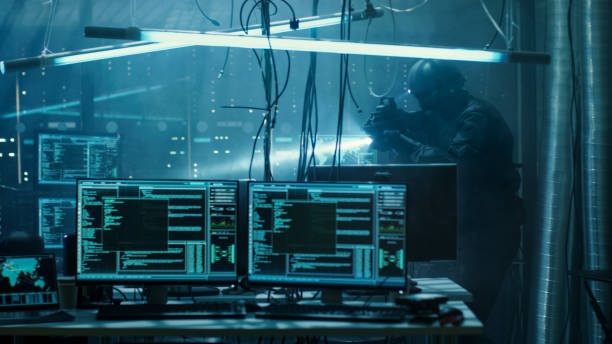 istock Cyber War Special Forces Fully Armed Soldier Uncovers Internationally Wanted Hacker's Hideout Place. Lair is Full of Monitors, Cables and Has Neon Lights. 817486172