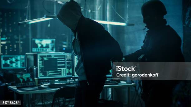 Fully Armed Special Cybersecurity Forces Soldier Arrests And Handcuffs Highly Dangerous Hacker Hideout Is Dark And Full Of Computer Equipment Stock Photo - Download Image Now