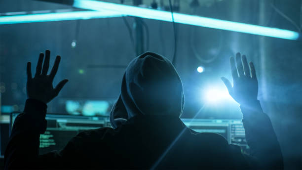 istock Fully Armed Special Cybersecurity Forces Soldier Arrests Highly Dangerous Hacker. Hideout is Dark and Full of Computer Equipment. 817486420