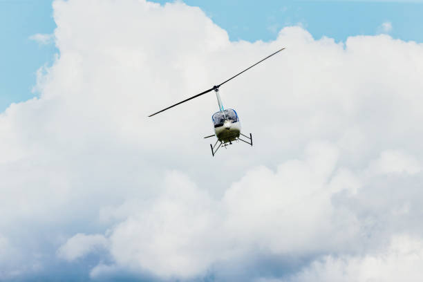 istock helicopter flying in blue sky and clouds 817500506