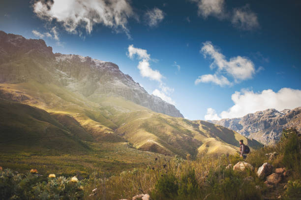 Side view of a Beautiful woman with woolly hat standing in a valley with snow capped mountains Jonkershoek Stellenbosch Cape Town South Africa