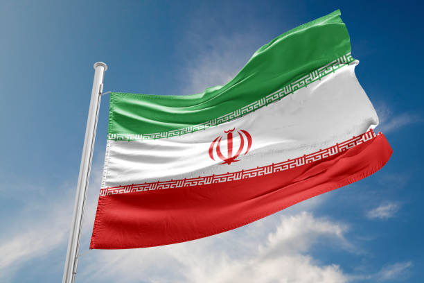 istock Iran Flag is Waving Against Blue Sky 817514724