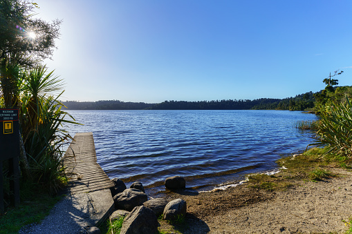 Beautiful Lake Ianthe or Matahi is West Coast's forest-lined fresh blue water lakes , popular for camping , boating, swimming, and trout fishing , South Island of New Zealand