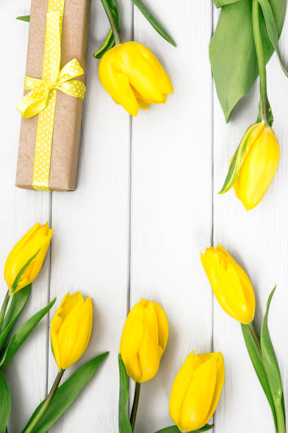 istock Flatlay with yellow tulips and gift present in craft paper 817521548