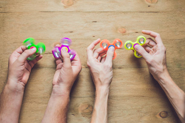 istock A man hand holding hand spinner or fidget spinner over wooden background 817528044