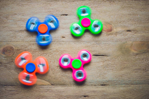 istock Colored fidget spinners stress relieving toy on wooden background 817528708