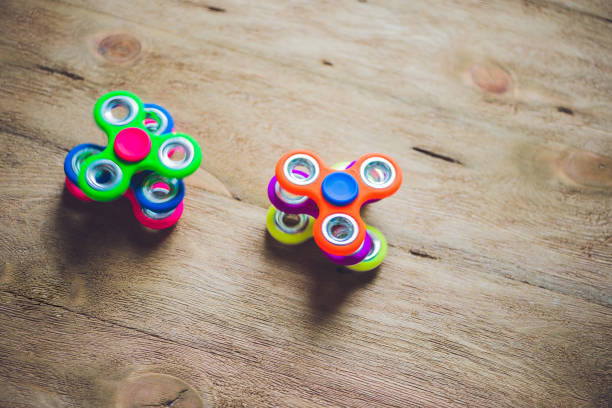 istock Colored fidget spinners stress relieving toy on wooden background 817530344