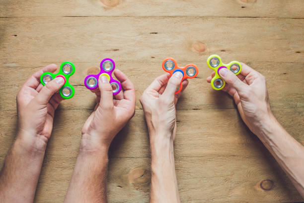 istock A man hand holding hand spinner or fidget spinner over wooden background 817530456