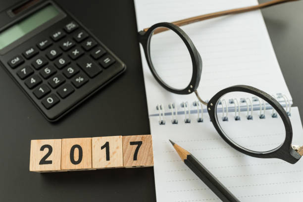istock financial target concept as selective focus on number 2018 wooden block with glasses, calculator, pencil, notebook 817532968