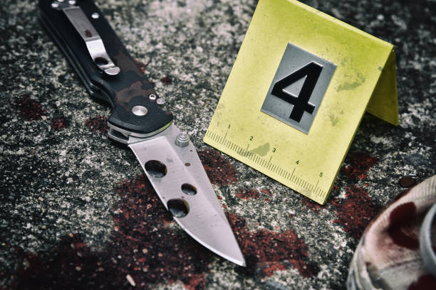 Crime scene investigation, Bloody knife and victim's shoes with criminal markers on ground Crime scene investigation, Bloody knife and victim's shoes with criminal markers on ground, Homicide evidence. knife weapon photos stock pictures, royalty-free photos & images
