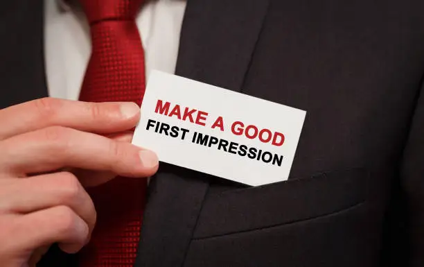 Photo of Businessman putting a card with text Make a good first impression in the pocket